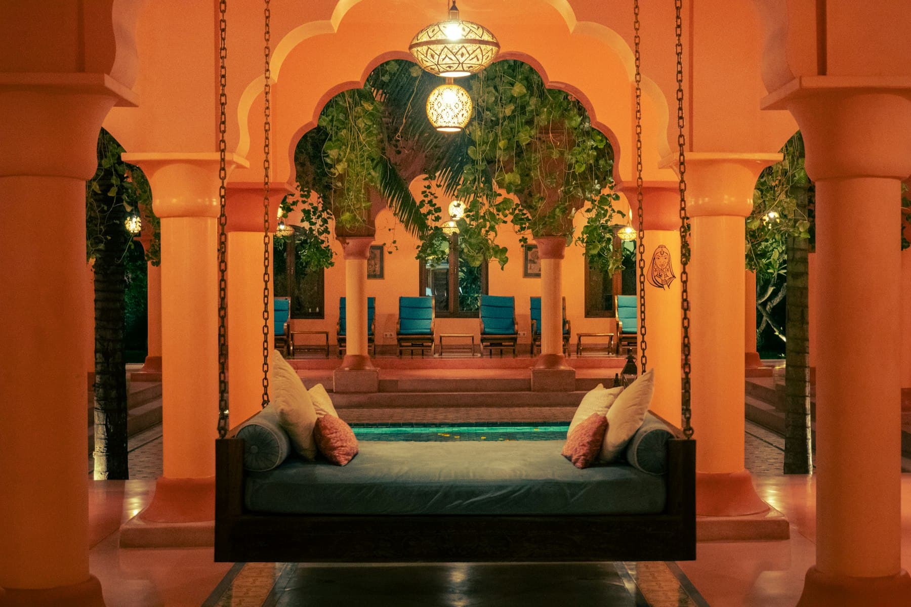 Arched sandstone courtyard lit by lanterns