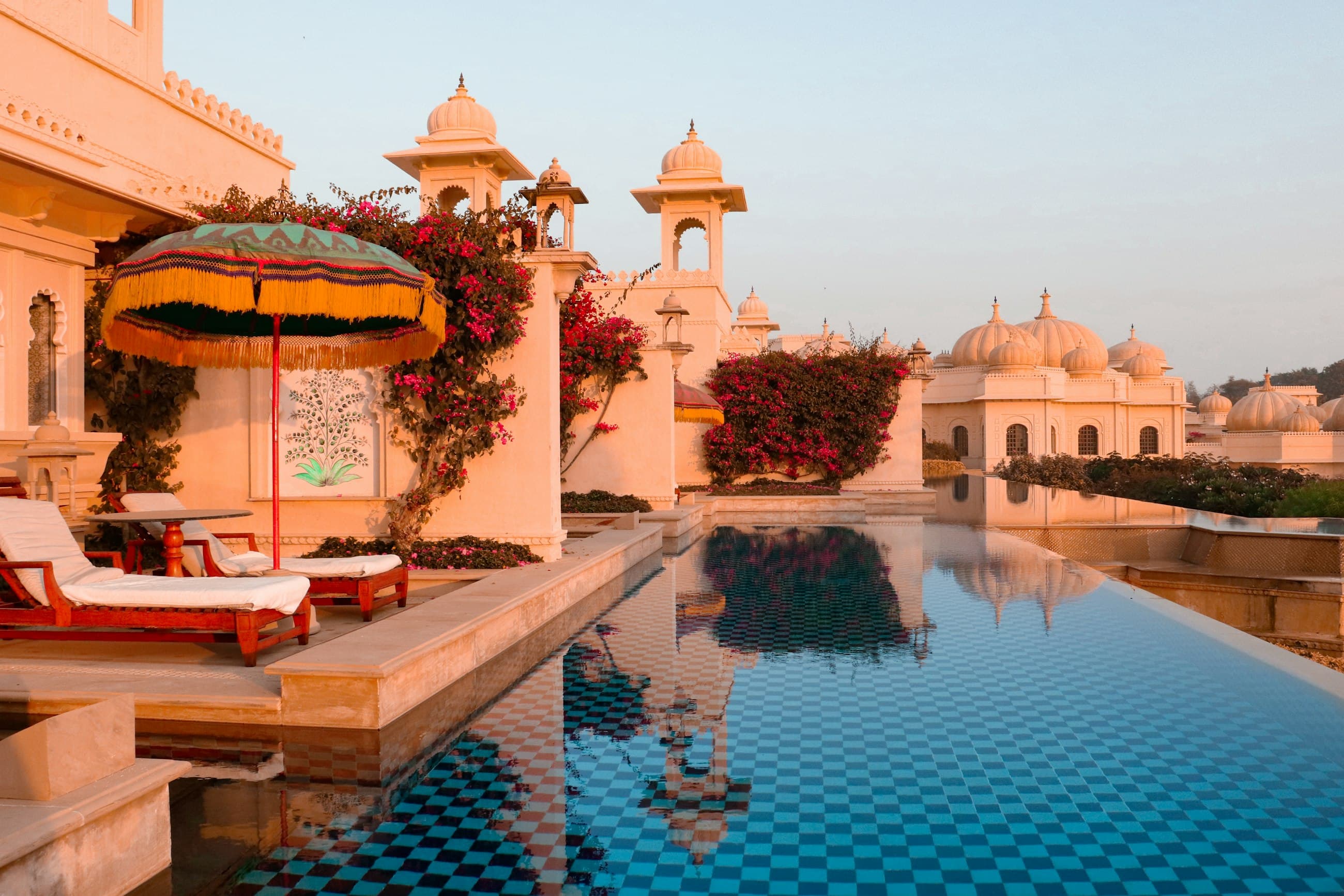 Infinity pool beside domed sandstone pavilions and bougainvillea at a Rajasthan residence